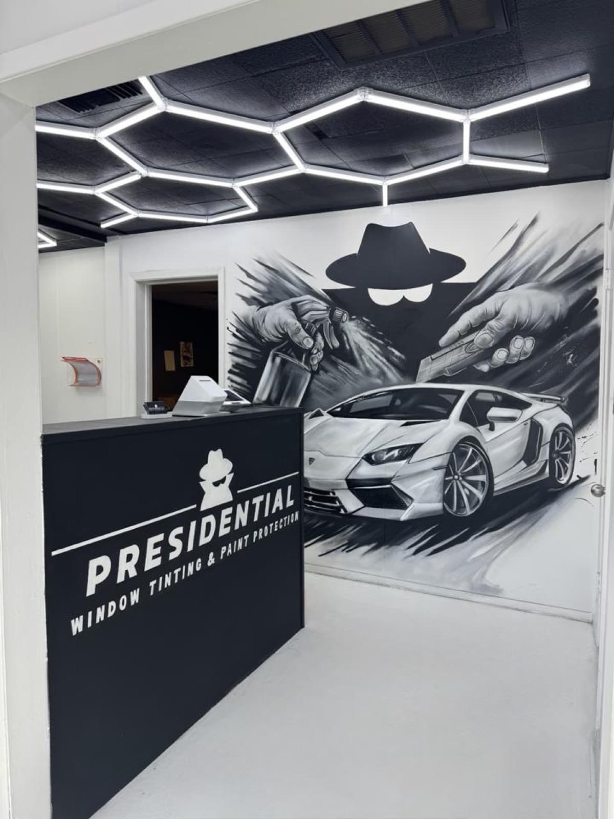 Presidential Tint front desk with branded mural inside the Midland shop.